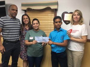 Brandon Simmonds presents donation to Anthony’s mother, Rosa Martinez-Vaquedano, with (L-R) the student’s parents, Marcus and Monique, and Colleen Mellott of Cayman Heart Fund